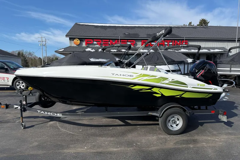 Slide: The Image of 2022 Tahoe T18 boat on trailer at dealership, featuring sleek design and vibrant graphics. - 12