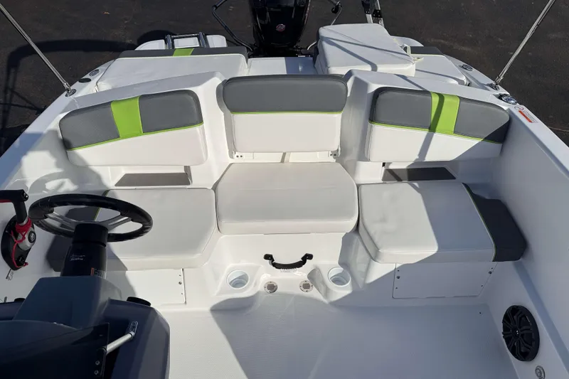 Slide: The Image of 2022 Tahoe T18 boat interior with gray and green seating, steering wheel, and storage compartments. - 5