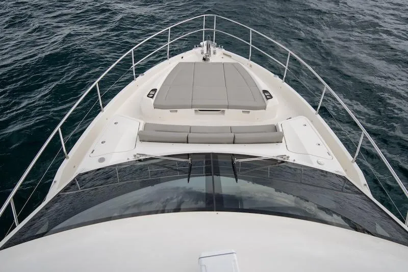 Slide: The Image of 2023 Absolute 62 Fly yacht bow view with sunpad, cruising on open water. - 29