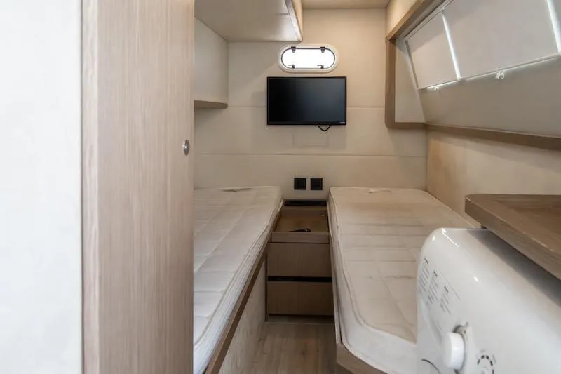Slide: The Image of 2023 Absolute 62 Fly yacht cabin with twin beds, TV, and modern decor. - 66
