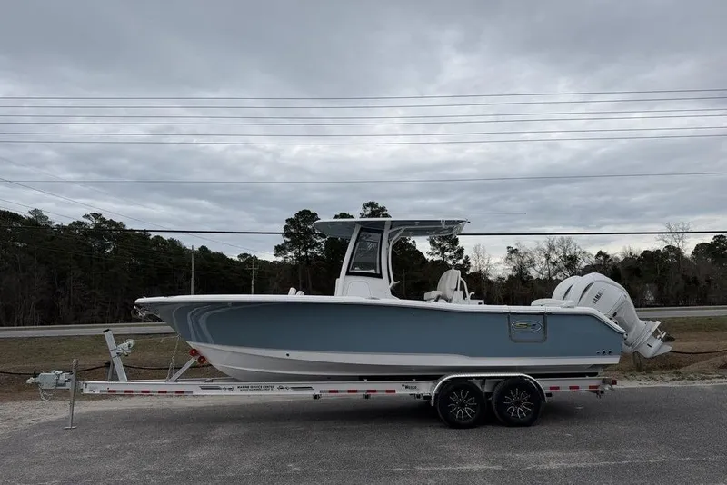 The Image of 2026 Sea Hunt Ultra 265 SE boat on trailer, parked outdoors under cloudy sky. - 1