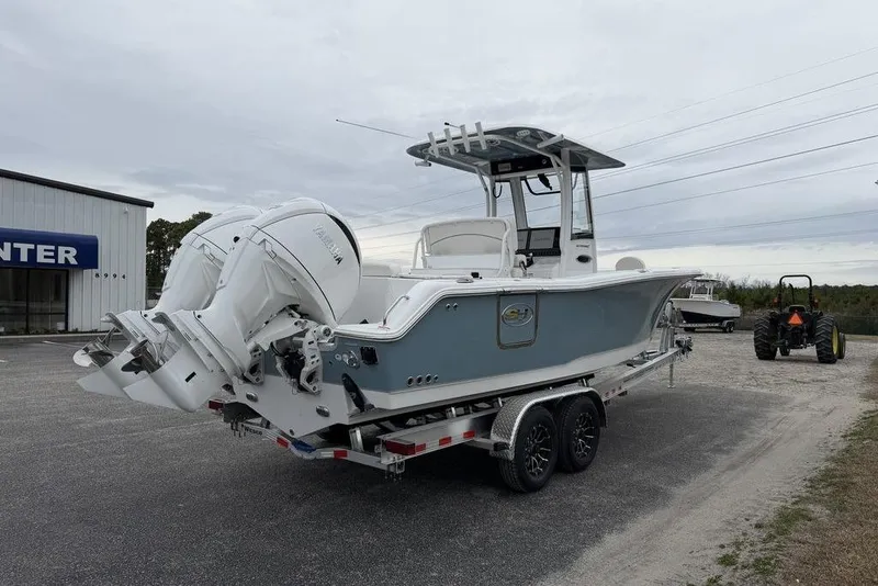 Slide: The Image of 2026 Sea Hunt Ultra 265 SE boat on trailer, dual engines, parked outdoors. - 10