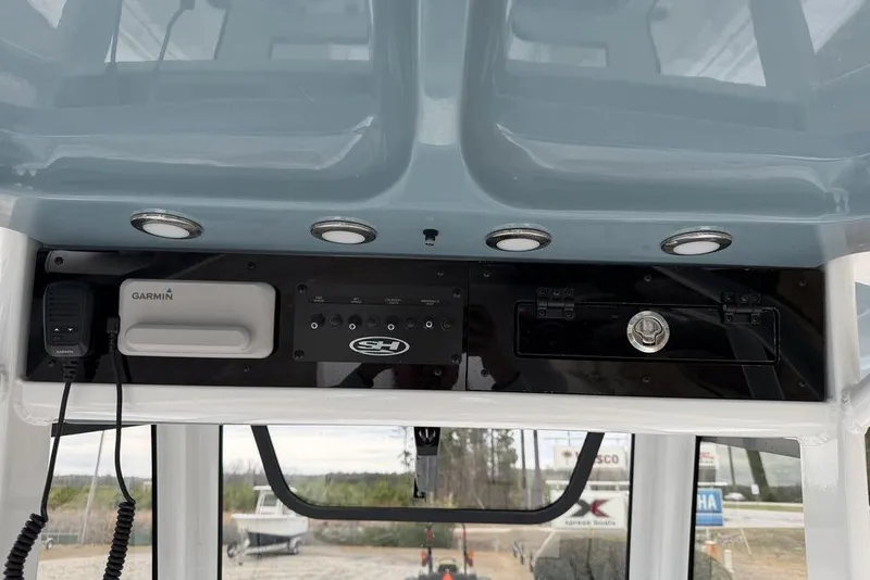 Slide: The Image of 2026 Sea Hunt Ultra 265 SE boat console with Garmin equipment and storage compartments. - 14
