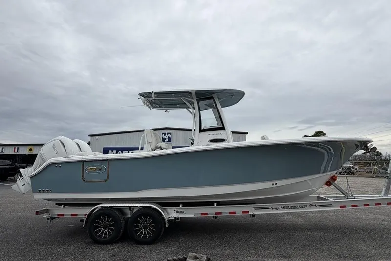 Slide: The Image of 2026 Sea Hunt Ultra 265 SE boat on trailer, side view under cloudy sky. - 3
