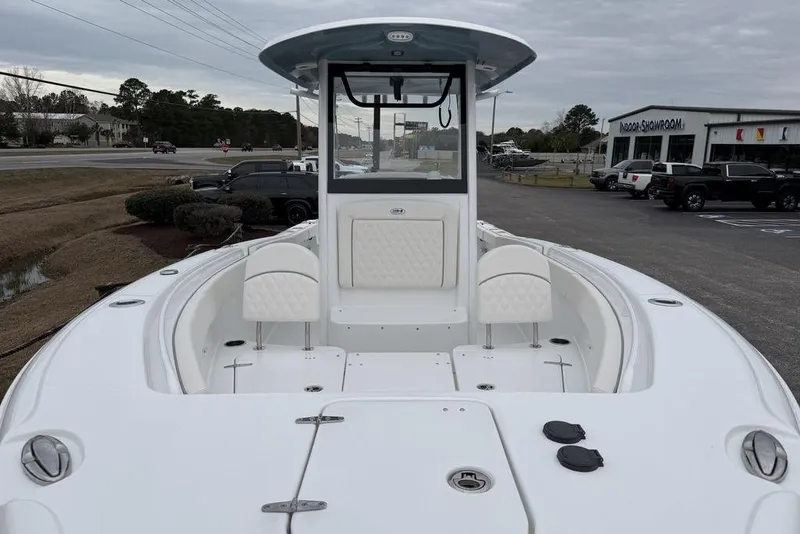 Slide: The Image of 2026 Sea Hunt Ultra 265 SE boat with spacious deck and seating, displayed outdoors. - 7