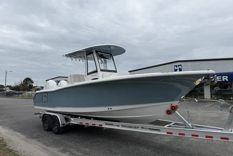 Slide: The Image of 2026 Sea Hunt Ultra 265 SE boat on trailer, parked outside a marine service center. - 9
