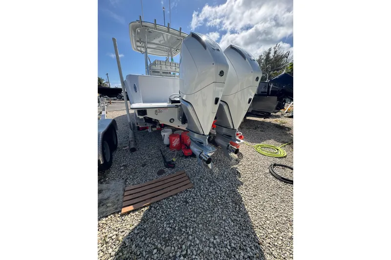 Slide: The Image of 2025 Contender 30 Tournament boat with dual outboard engines on gravel. - 6