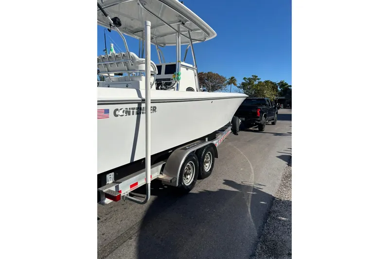 Slide: The Image of 2025 Contender 30 Tournament boat on trailer, parked on sunny street. - 7