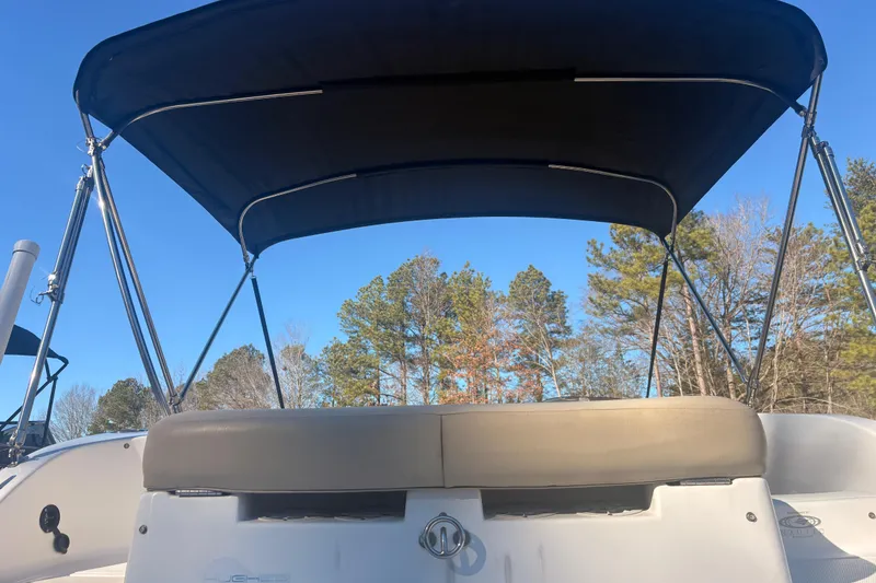 Slide: The Image of 2015 Hurricane SunDeck Sport 188 IO boat with canopy, set against a clear blue sky. - 7