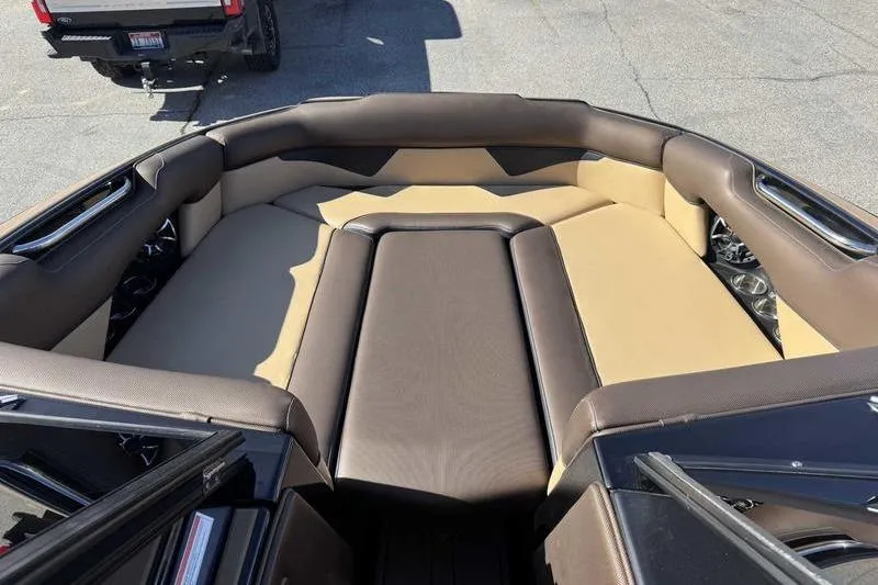 Slide: The Image of 2021 Moomba Makai boat interior with brown and beige seating, parked outdoors. - 14