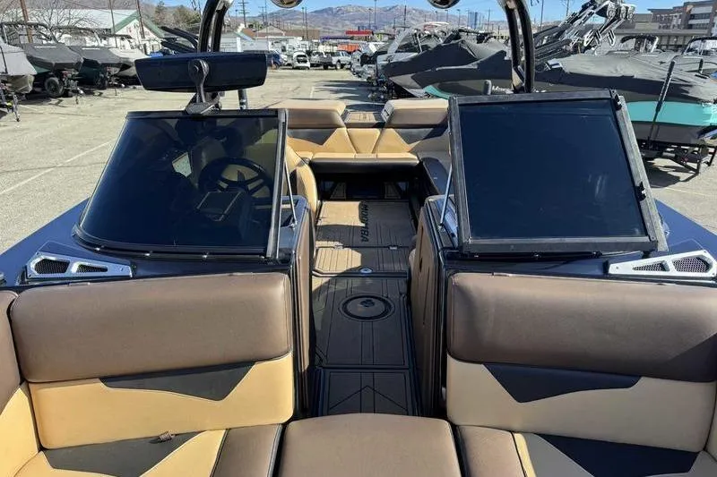 Slide: The Image of 2021 Moomba Makai boat interior with tan and brown seating, parked outdoors. - 15