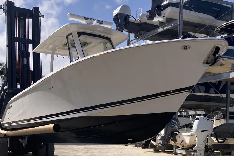 Slide: The Image of 2019 Pursuit S 288 Sport boat on forklift, marina background. - 16