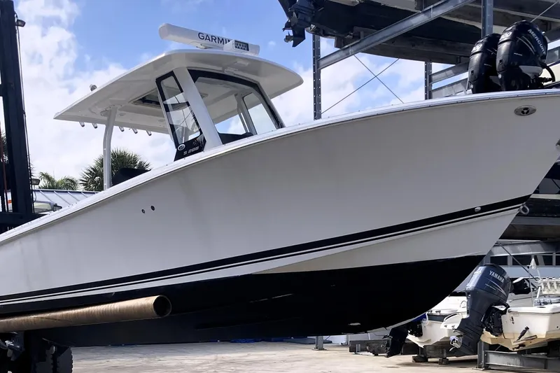 Slide: The Image of 2019 Pursuit S 288 Sport boat on lift, featuring sleek design and dual engines. - 17
