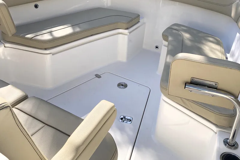 Slide: The Image of 2019 Pursuit S 288 Sport boat interior with beige cushioned seating and white deck. - 24