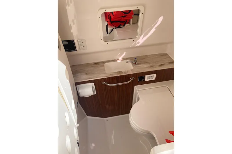 Slide: The Image of 2019 Pursuit S 288 Sport boat interior with sink, mirror, and storage. - 26