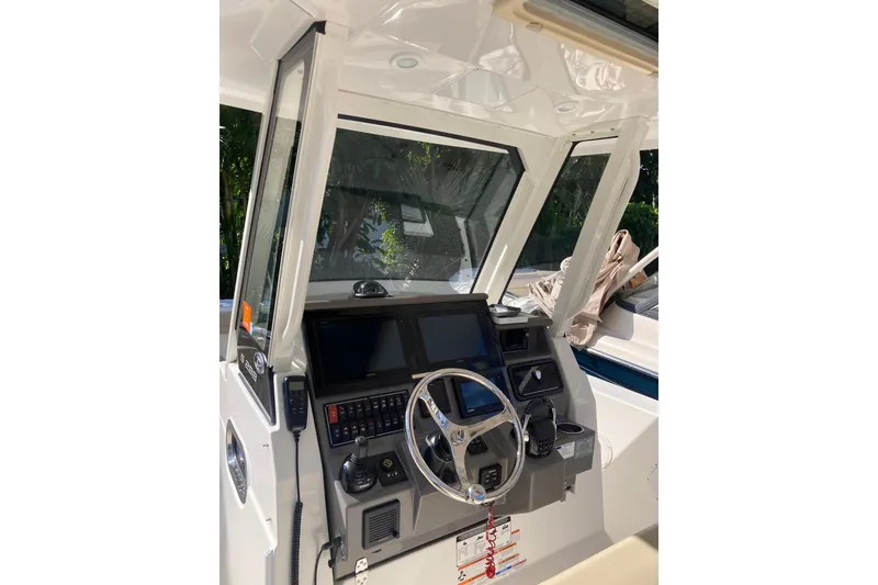 Slide: The Image of 2019 Pursuit S 288 Sport boat dashboard with steering wheel and navigation controls. - 32