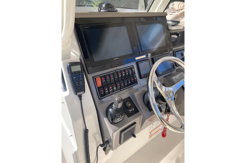 Slide: The Image of 2019 Pursuit S 288 Sport boat dashboard with dual screens and controls. - 42