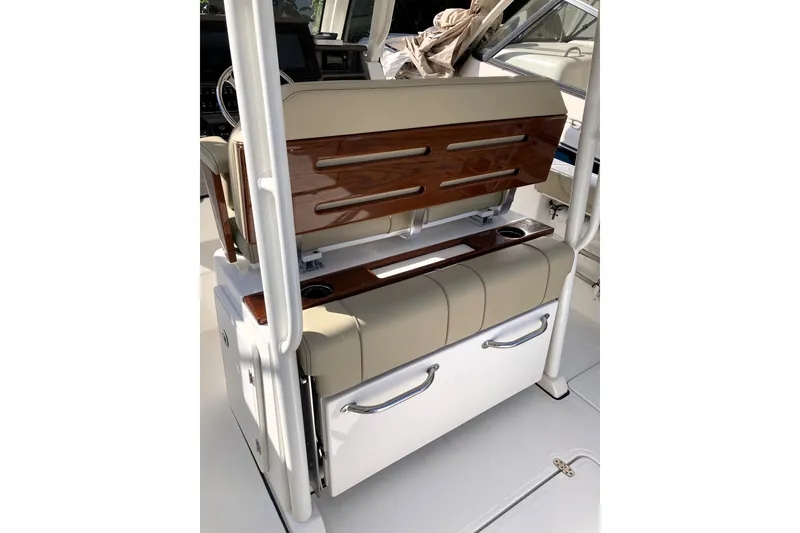 Slide: The Image of 2019 Pursuit S 288 Sport boat interior with beige seating and wood accents. - 48