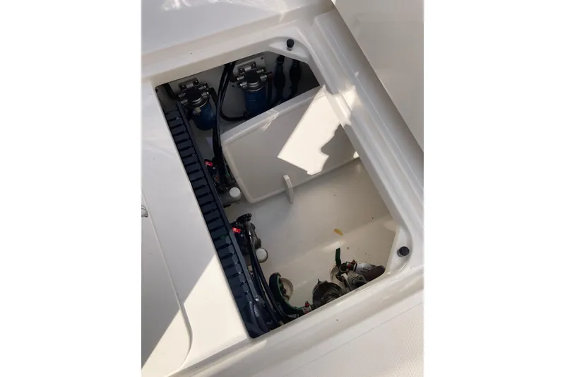 Slide: The Image of 2019 Pursuit S 288 Sport boat storage compartment with visible wiring and components. - 57