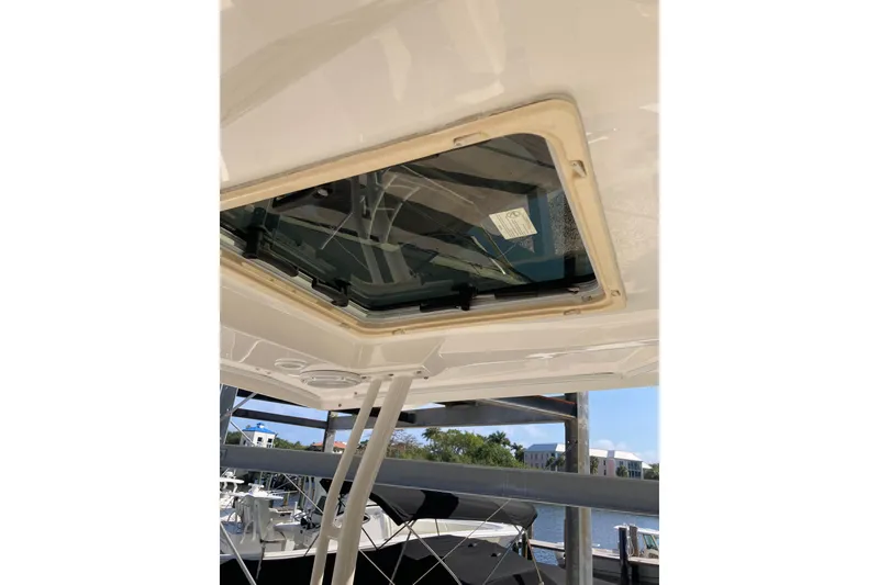 Slide: The Image of 2019 Pursuit S 288 Sport boat with open sunroof, docked near water. - 62