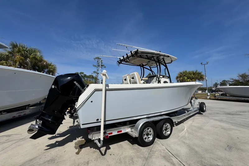 Slide: The Image of 2019 Sailfish 270 CC boat on trailer, parked outdoors under clear blue sky. - 10