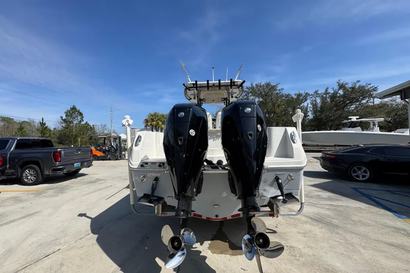 Slide: The Image of 2019 Sailfish 270 CC boat with dual outboard motors in a parking lot. - 12