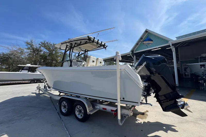 Slide: The Image of 2019 Sailfish 270 CC boat on trailer with Mercury engine, parked outdoors. - 14