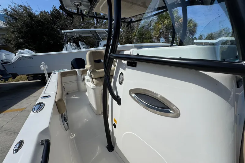 Slide: The Image of 2019 Sailfish 270 CC boat interior with seating and console, parked outdoors. - 22