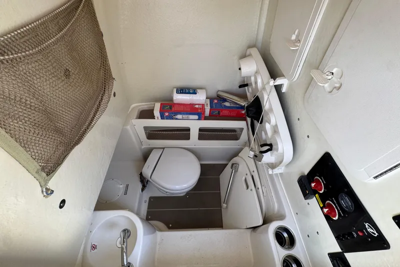 Slide: The Image of 2019 Sailfish 270 CC boat interior with compact bathroom amenities and storage. - 23