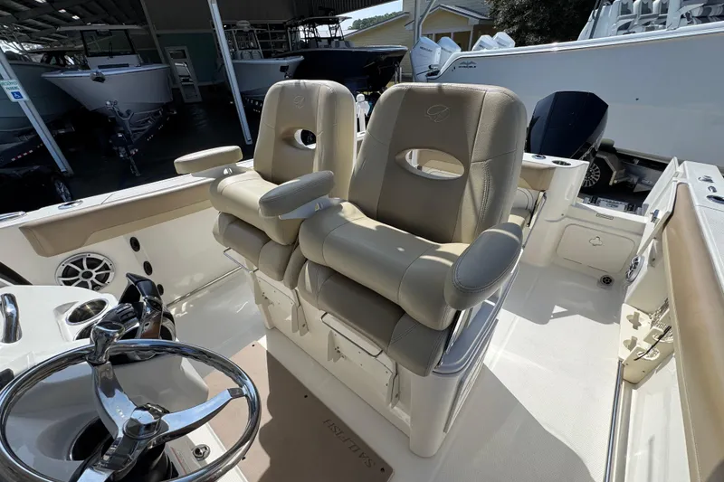 Slide: The Image of 2019 Sailfish 270 CC boat interior with dual captain's chairs and steering wheel. - 24