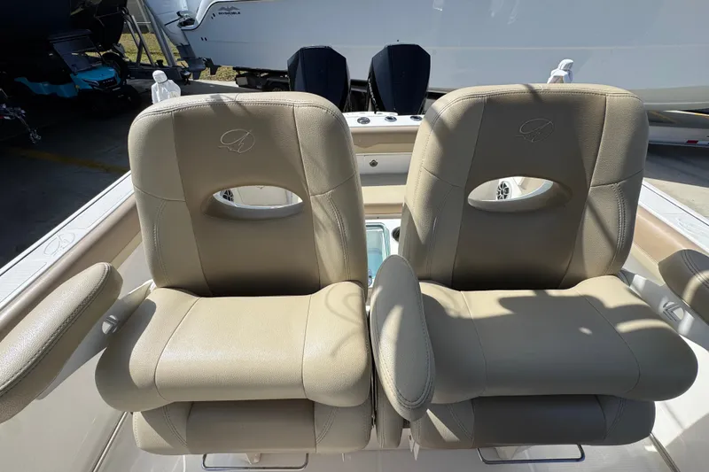Slide: The Image of 2019 Sailfish 270 CC boat with beige captain chairs and dual outboard motors. - 25