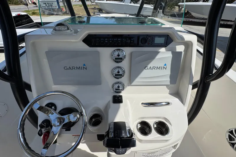 Slide: The Image of 2019 Sailfish 270 CC boat dashboard with Garmin displays and steering wheel. - 28