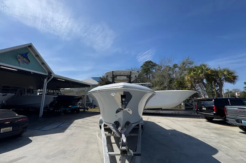 Slide: The Image of 2019 Sailfish 270 CC boat on trailer, parked outdoors under clear blue sky. - 5