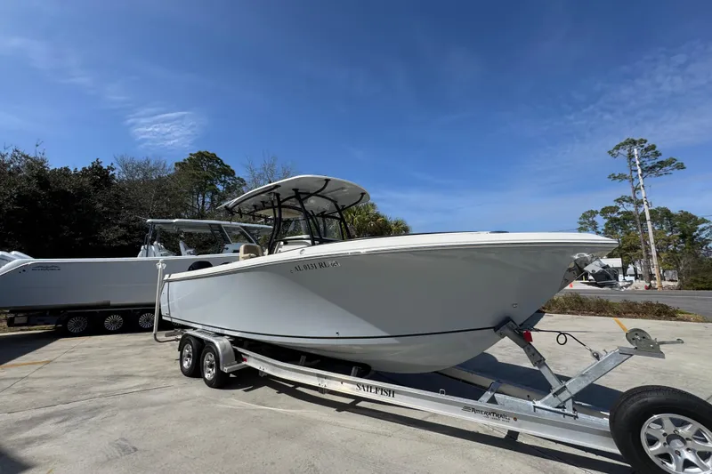 Slide: The Image of 2019 Sailfish 270 CC boat on trailer under clear blue sky. - 7