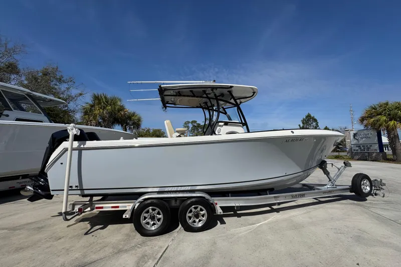 Slide: The Image of 2019 Sailfish 270 CC boat on trailer, parked outdoors under clear blue sky. - 9