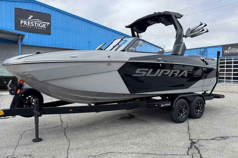 Slide: The Image of 2026 Supra SA boat on trailer at Prestige Water Sports dealership. - 4