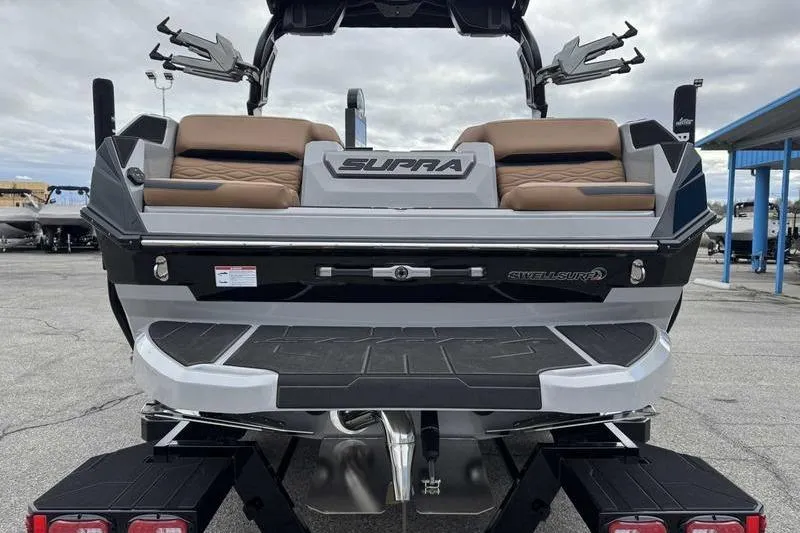 Slide: The Image of 2026 Supra SA boat rear view with tan seating and Swell Surf system. - 6
