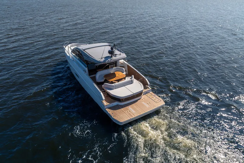 Slide: The Image of 2026 Beneteau Gran Turismo 50 yacht cruising on open water, rear view. - 10