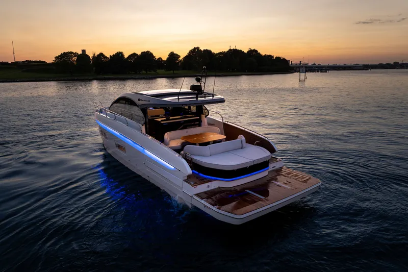 Slide: The Image of 2026 Beneteau Gran Turismo 50 yacht cruising at sunset with illuminated deck. - 4