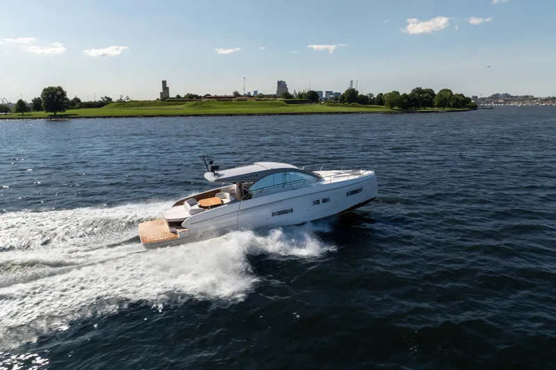 Slide: The Image of 2026 Beneteau Gran Turismo 50 yacht cruising on open water, scenic shoreline in background. - 17