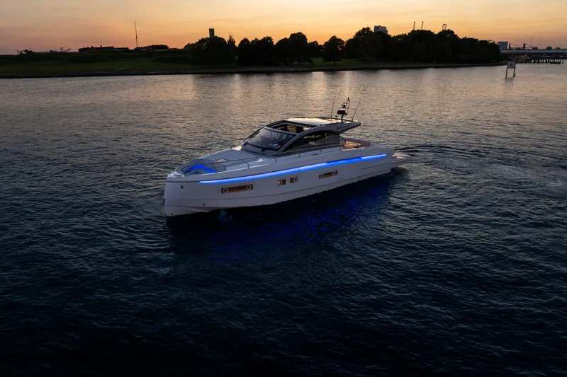 Slide: The Image of 2026 Beneteau Gran Turismo 50 yacht cruising at sunset with illuminated blue accents. - 6
