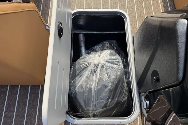 Slide: The Image of Open storage compartment on 2026 Premier 250 Solaris RF -CL boat, with bagged contents. - 13