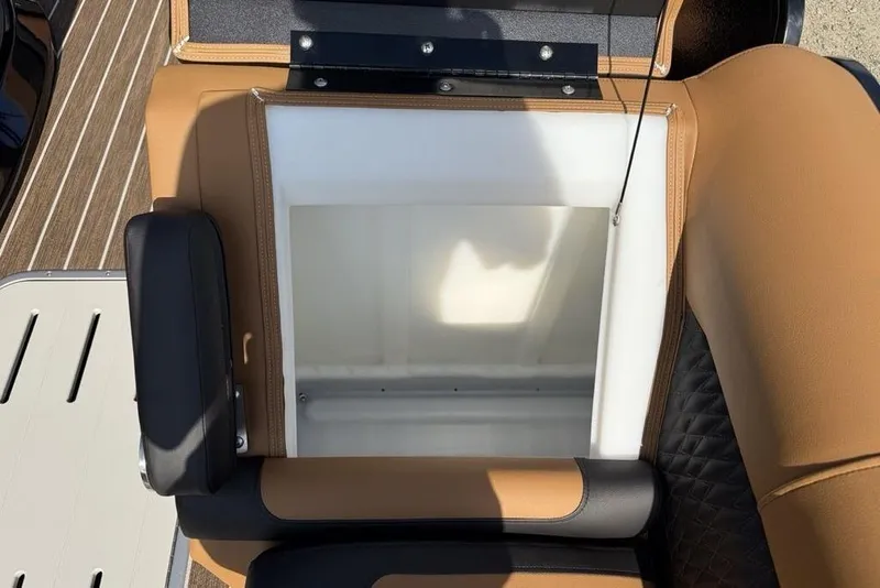 Slide: The Image of 2026 Premier 250 Solaris RF-CL boat seat storage compartment, open with tan and black upholstery. - 6