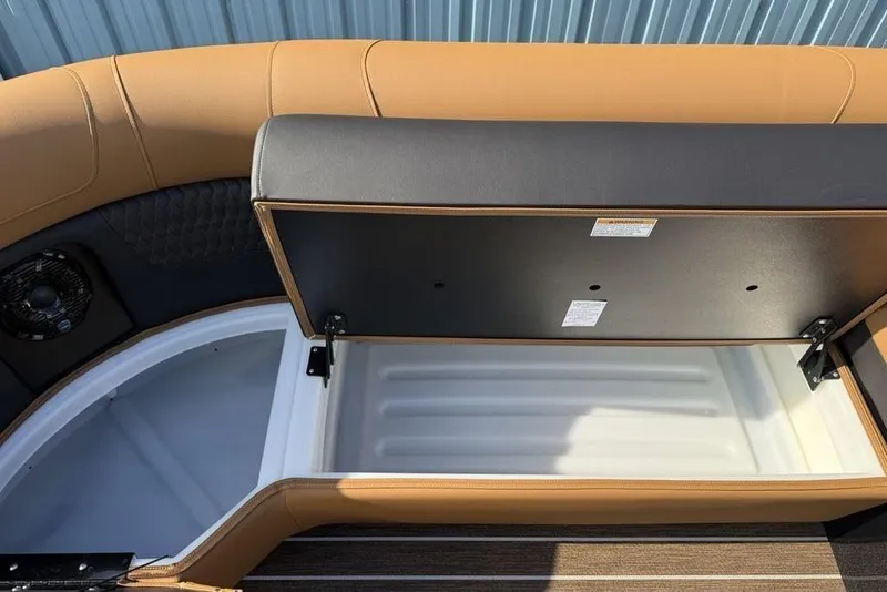 Slide: The Image of Open storage compartment in 2026 Premier 250 Solaris RF-CL boat, featuring tan upholstery. - 10
