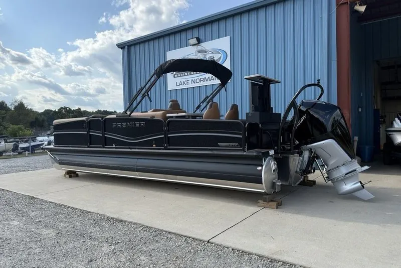 Slide: The Image of 2026 Premier 250 Solaris RF-CL pontoon boat parked outside a blue building. - 3