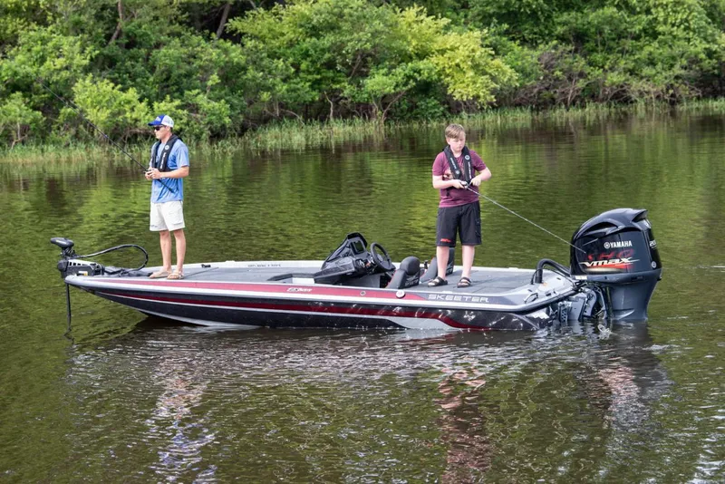 Slide: The Image of Manufacturer Provided Image: 2021 Skeeter ZX 200 fishing boat on a calm lake with two anglers. - 2