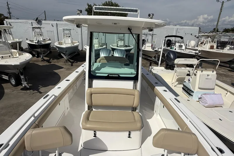 Slide: The Image of 2020 Everglades 273 Center Console boat with beige seating, displayed among other boats. - 16