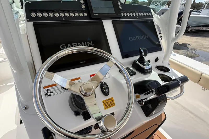 Slide: The Image of 2020 Everglades 273 Center Console boat dashboard with Garmin displays and steering wheel. - 19