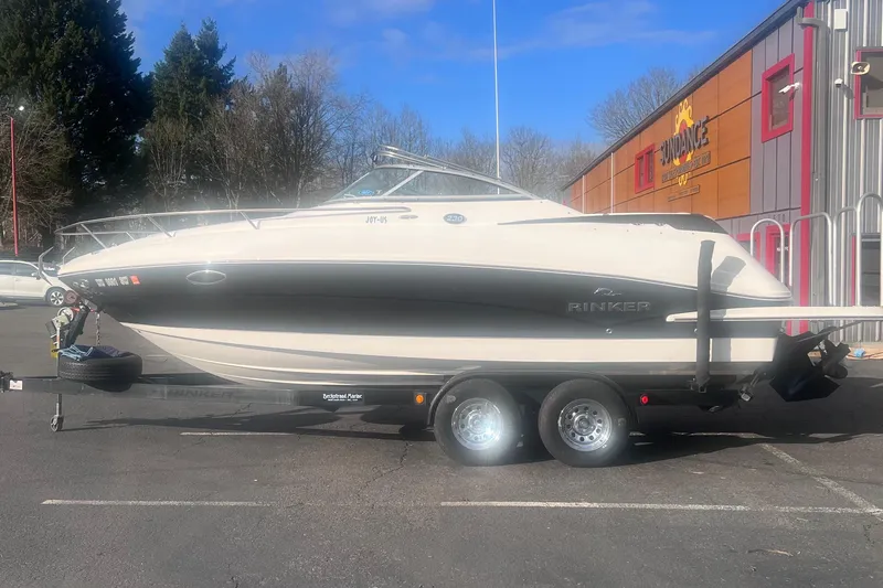 Slide: The Image of 2007 Rinker 230 Captiva Atlantic boat on trailer, parked outdoors near a building. - 7
