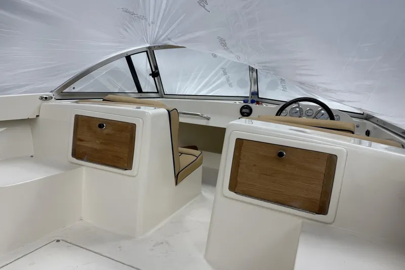 Slide: The Image of 2022 Rossiter 17 Closed Deck boat interior with wood accents and steering wheel. - 11